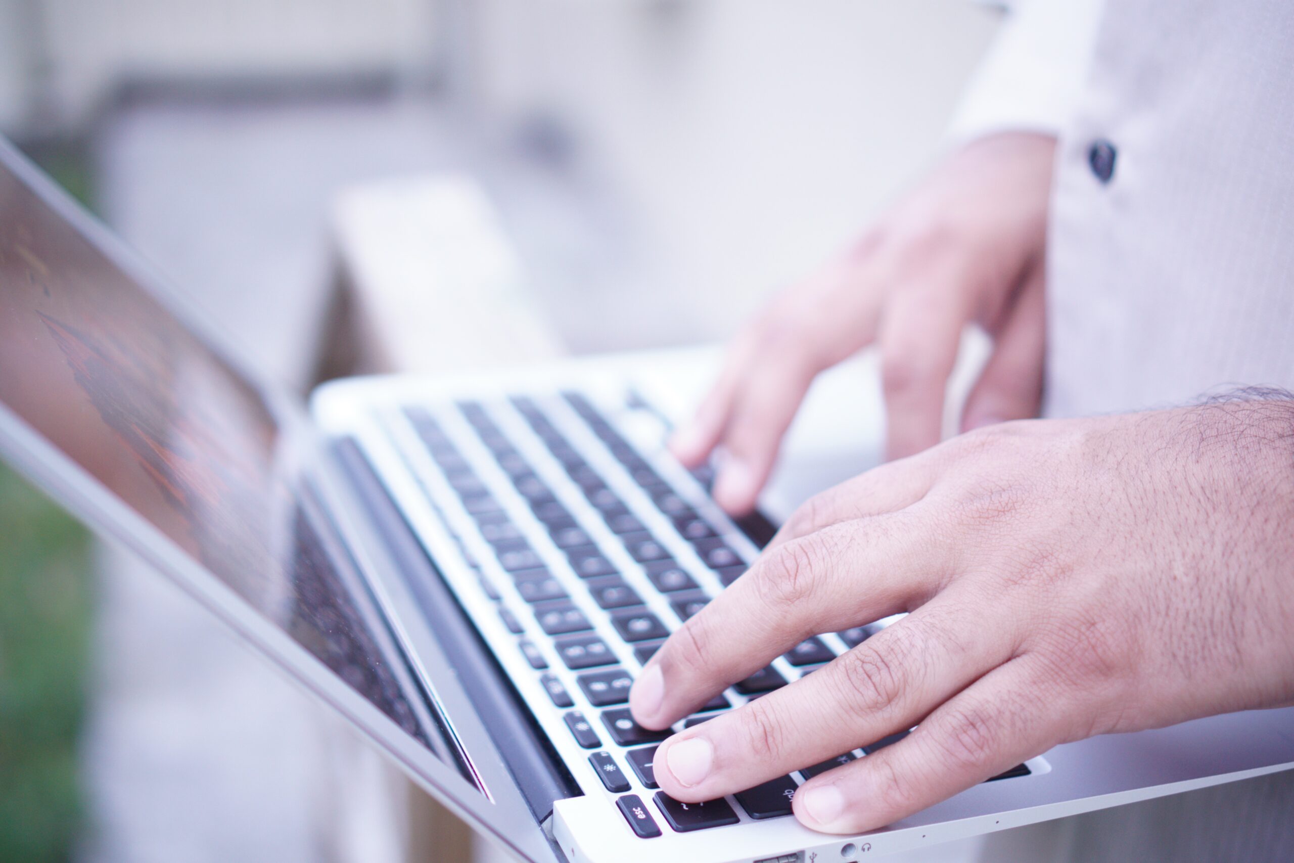 Close up of someone typing on a laptop